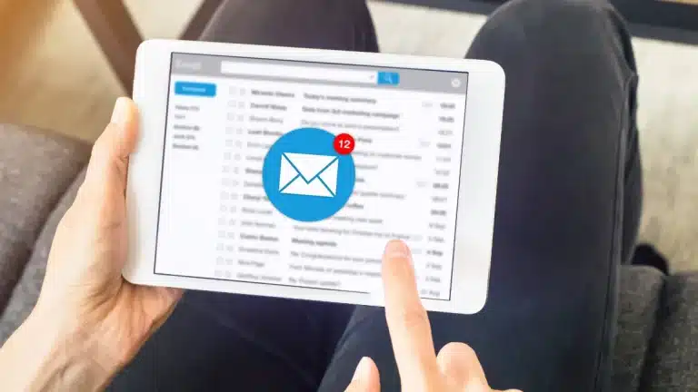 your guide to email marketing strategy for small businesses - image depicts point of view shot of a person holding a tablet, scrolling their emails.